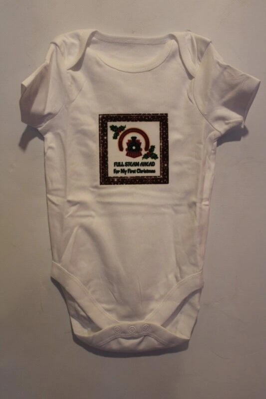 White baby onesie featuring the text "Full Steam Ahead For My First Christmas" alongside a train graphic, perfect for celebrating a baby's first festive season.